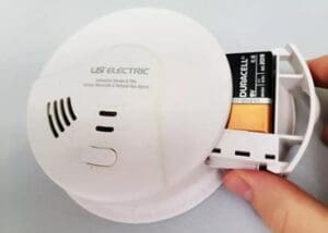 Someone changing the battery in their smoke detector